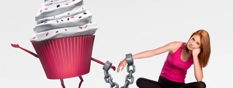 A woman is chained to a giant cupcake.