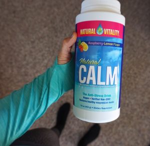 A person holding up a bottle of natural calm.