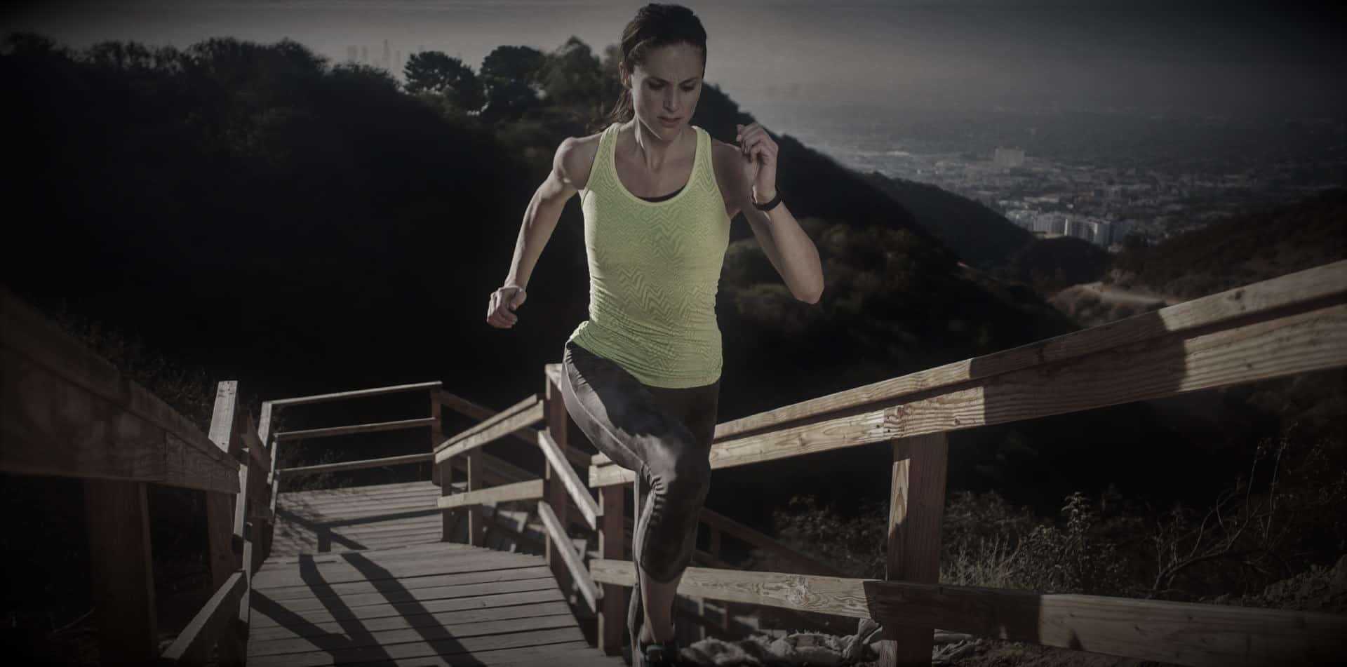 A woman running on top of a wooden bridge.
