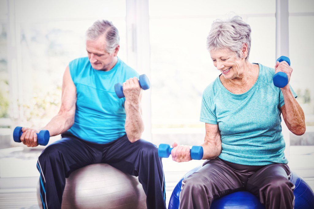 A man and woman are sitting on exercise balls.