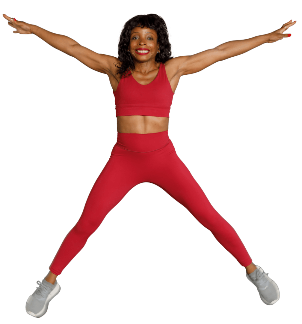 A woman in red is jumping up and smiling.