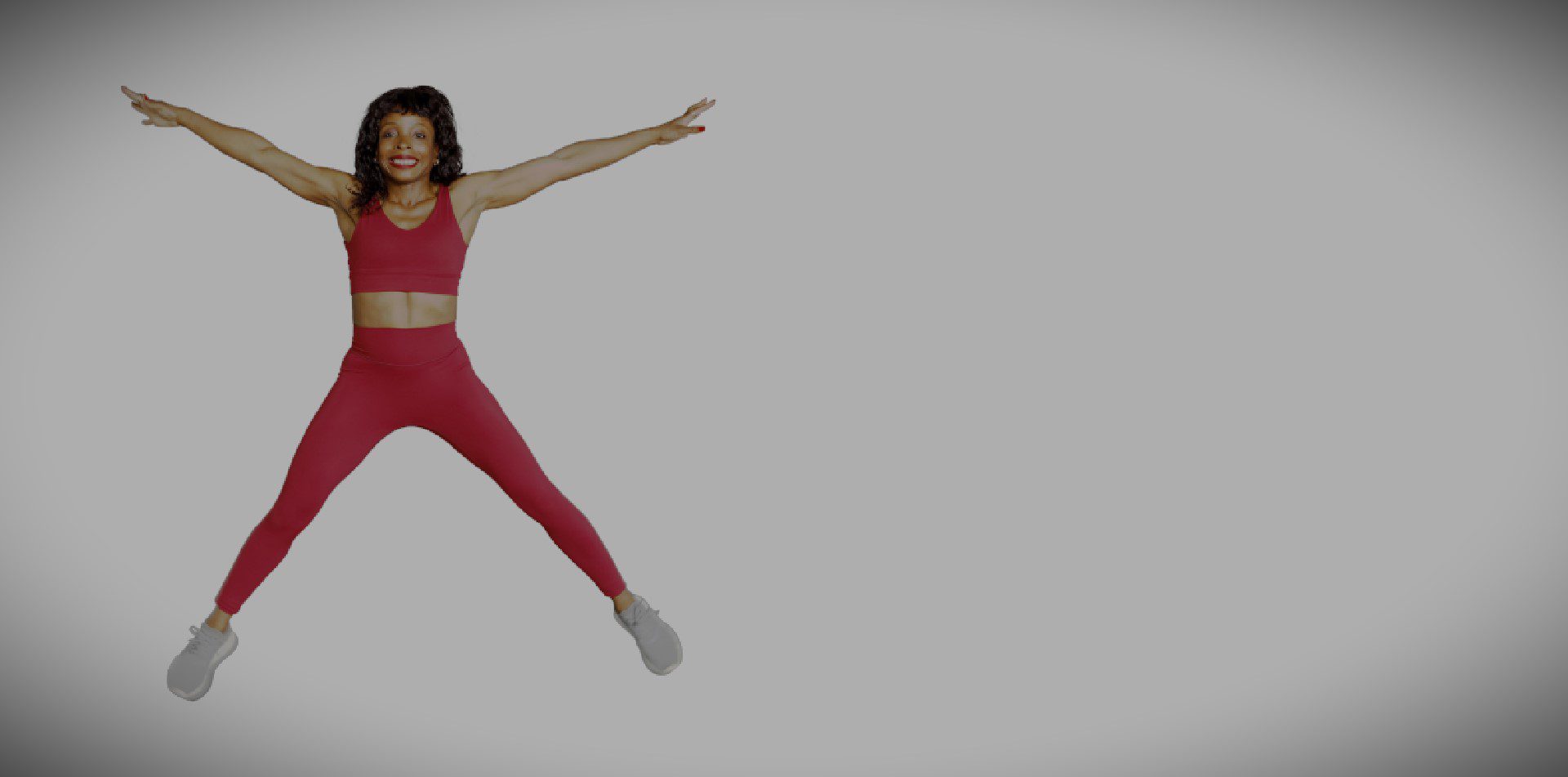A woman in red is jumping up and doing a trick